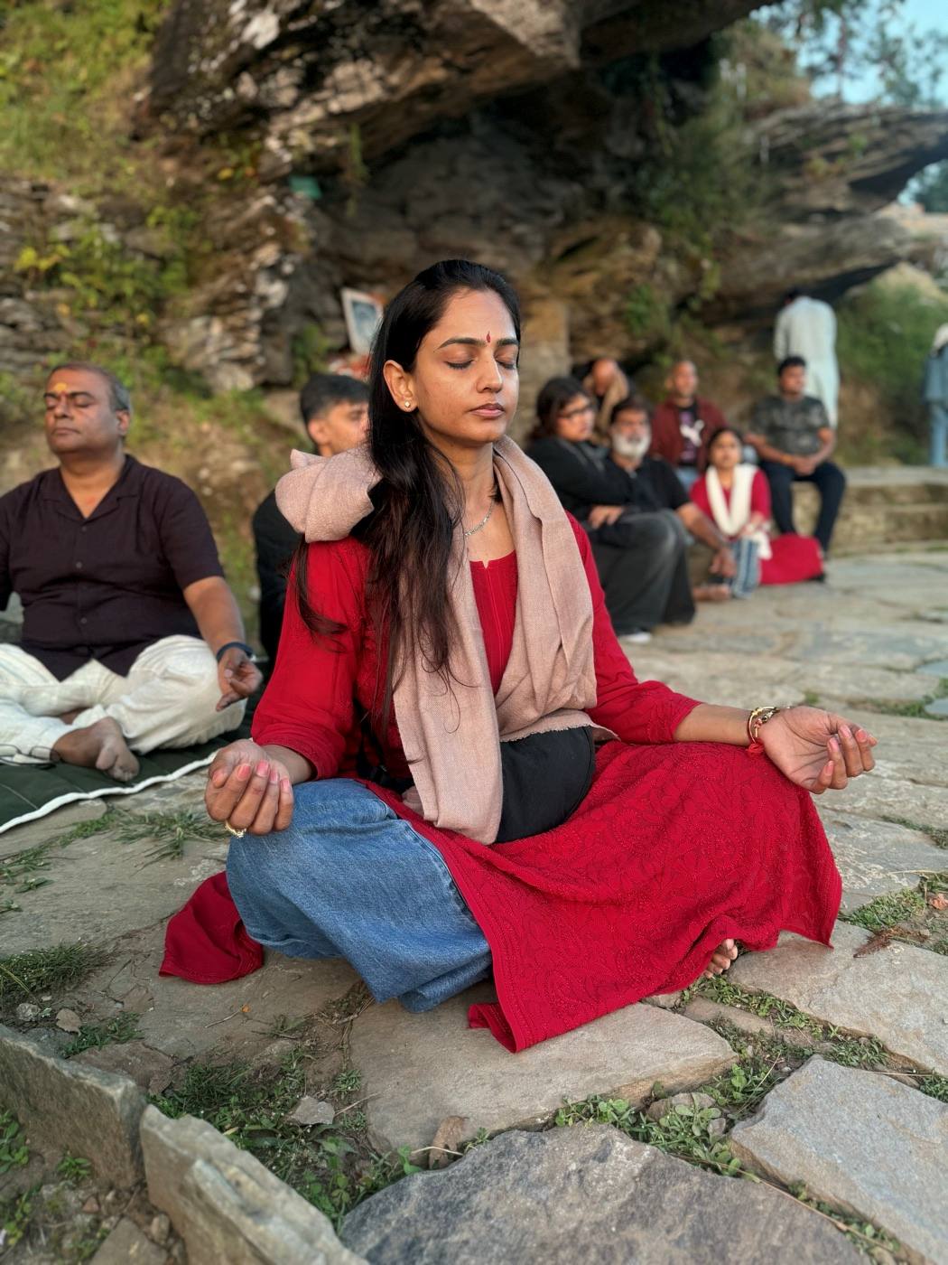 Seekers meditating together on the rocks at Kasar Devi.