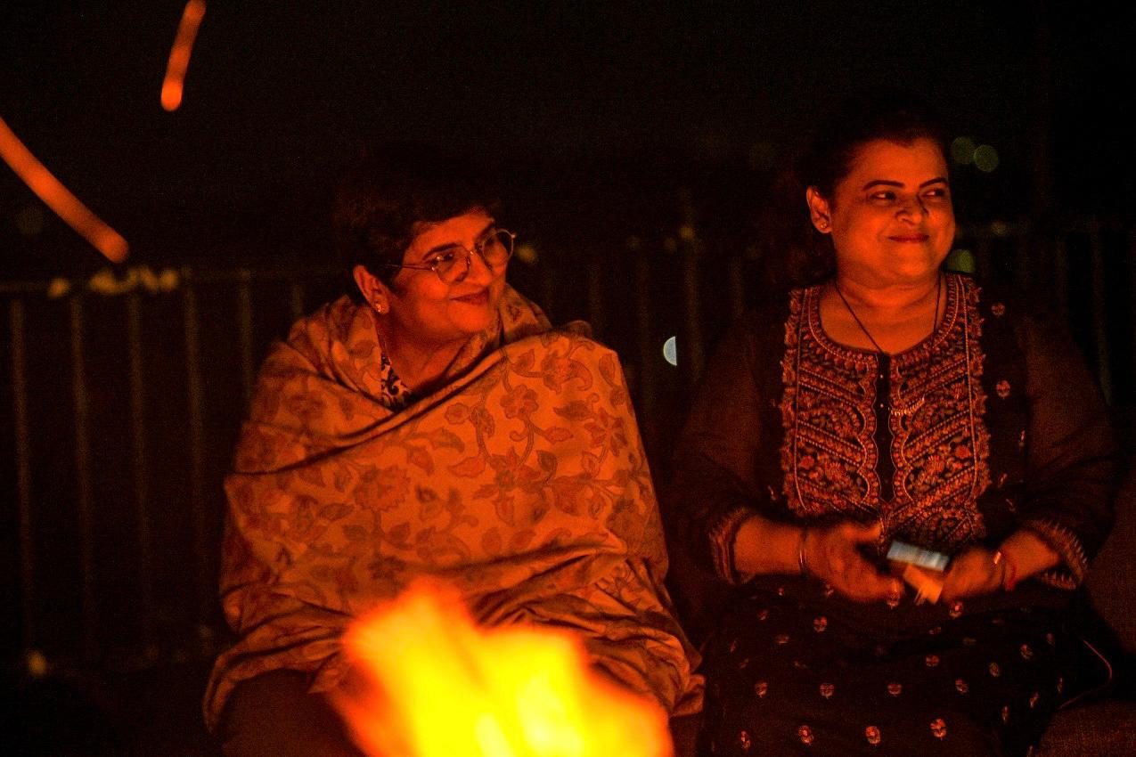 Two yatris sharing a smile by the evening bonfire.