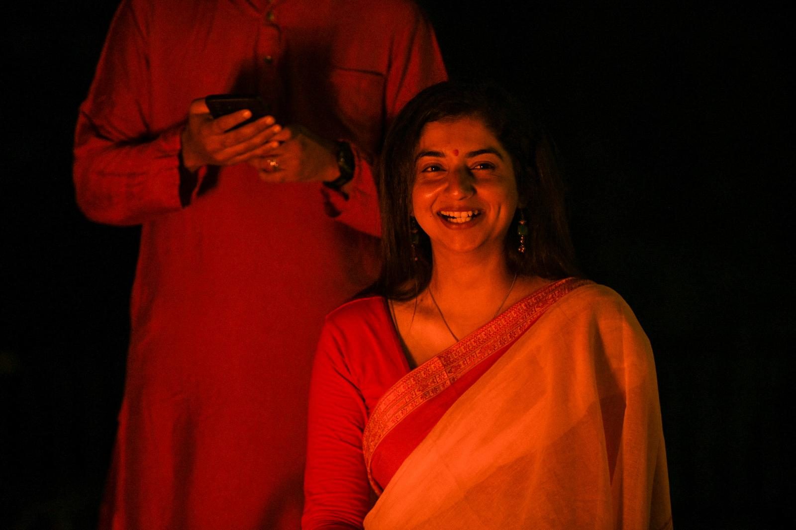 A yatri laughing in the warm glow of the bonfire.