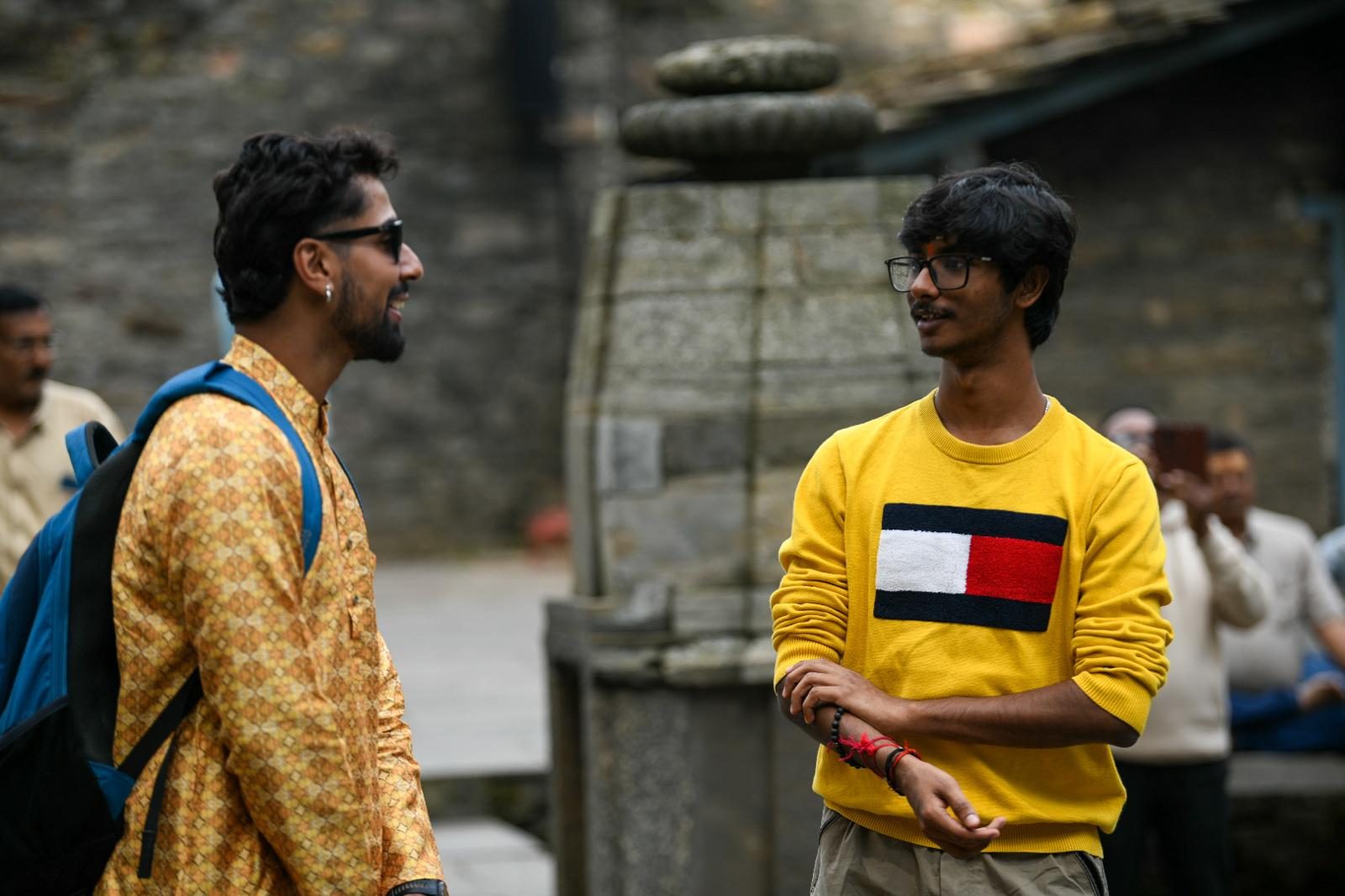 Two yatris talking and laughing at Jageshwar Dham.